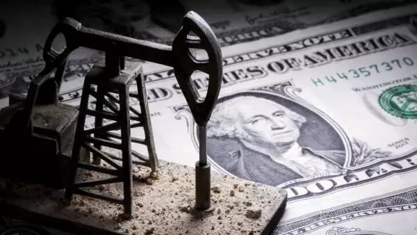 A 3D printed oil pump jack is placed on dollar banknotes in this illustration picture