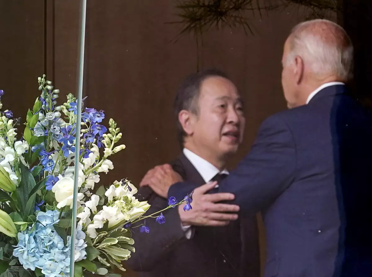 El presidente de Estados Unidos es visto a través de una ventana abrazando al embajador de Japón en Estados Unidos, Tomita Koji, antes de dar sus consolencias en memoria del ex primer ministro de Japón, Shinzo Abe. 