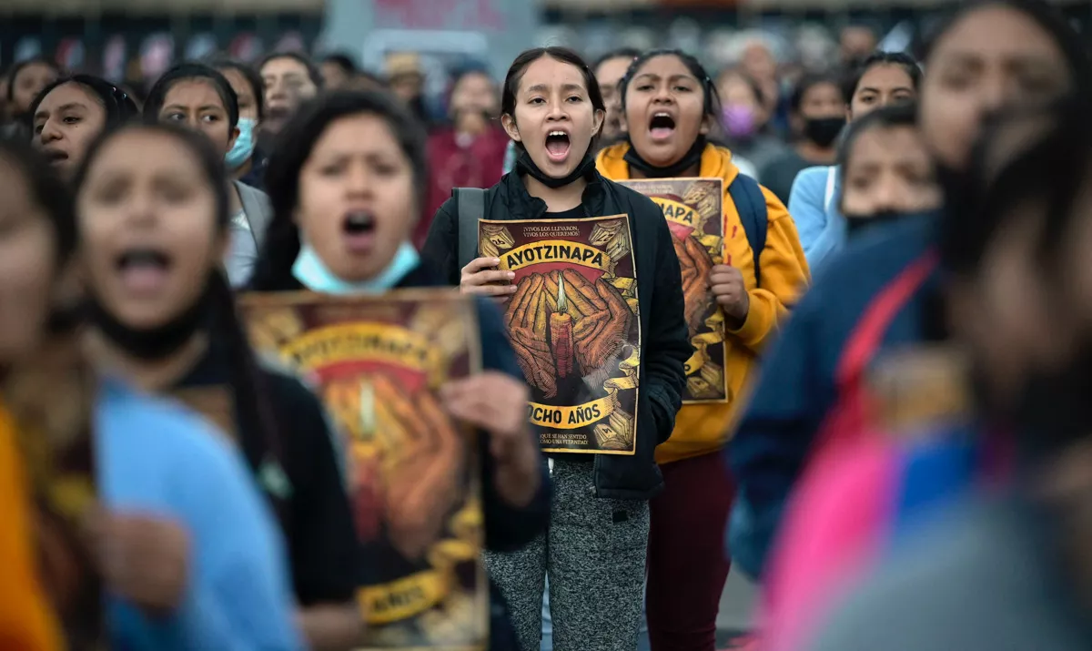 (La gente grita consignas durante una marcha en la plaza Zócalo de la Ciudad de México el 26 de septiembre de 2022, con motivo del octavo aniversario de la desaparición de 43 estudiantes de la escuela de formación docente en Ayotzinapa)