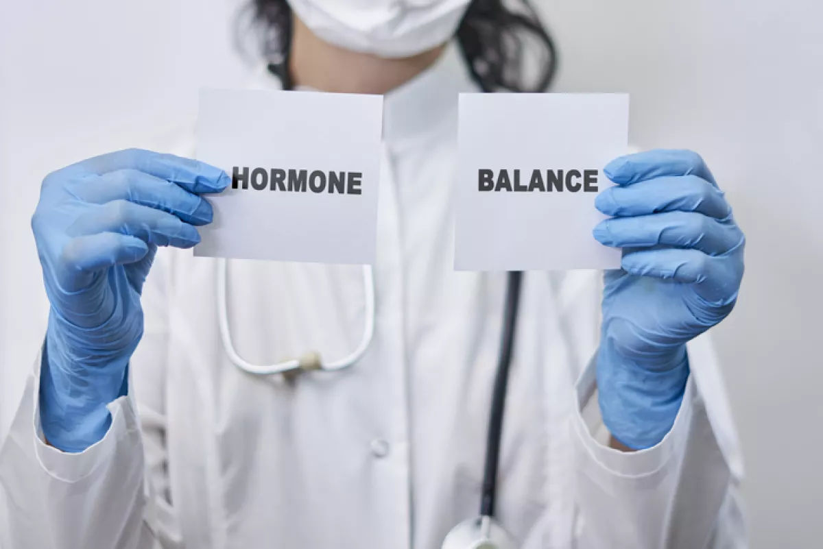 Doctora sosteniendo letrero que dice: "Hormone balance"
