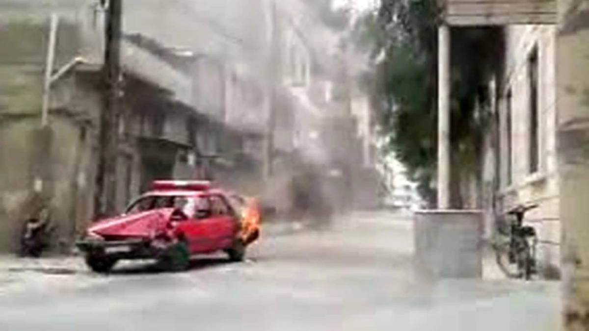 Un auto incendiado en las protestas en Homs