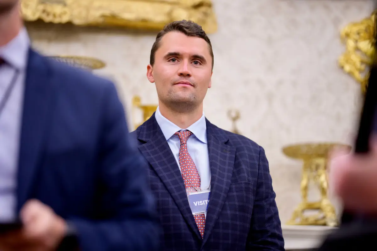 El cofundador de Turning Point USA, Charlie Kirk, se encuentra en la parte trasera de la sala mientras el presidente de los Estados Unidos, Donald Trump, habla durante una ceremonia de juramento para la fiscal interina de los Estados Unidos para Washington, D.C. Jeanine Pirro en la Oficina Oval de la Casa Blanca el 28 de mayo de 2025 en Washington, DC.