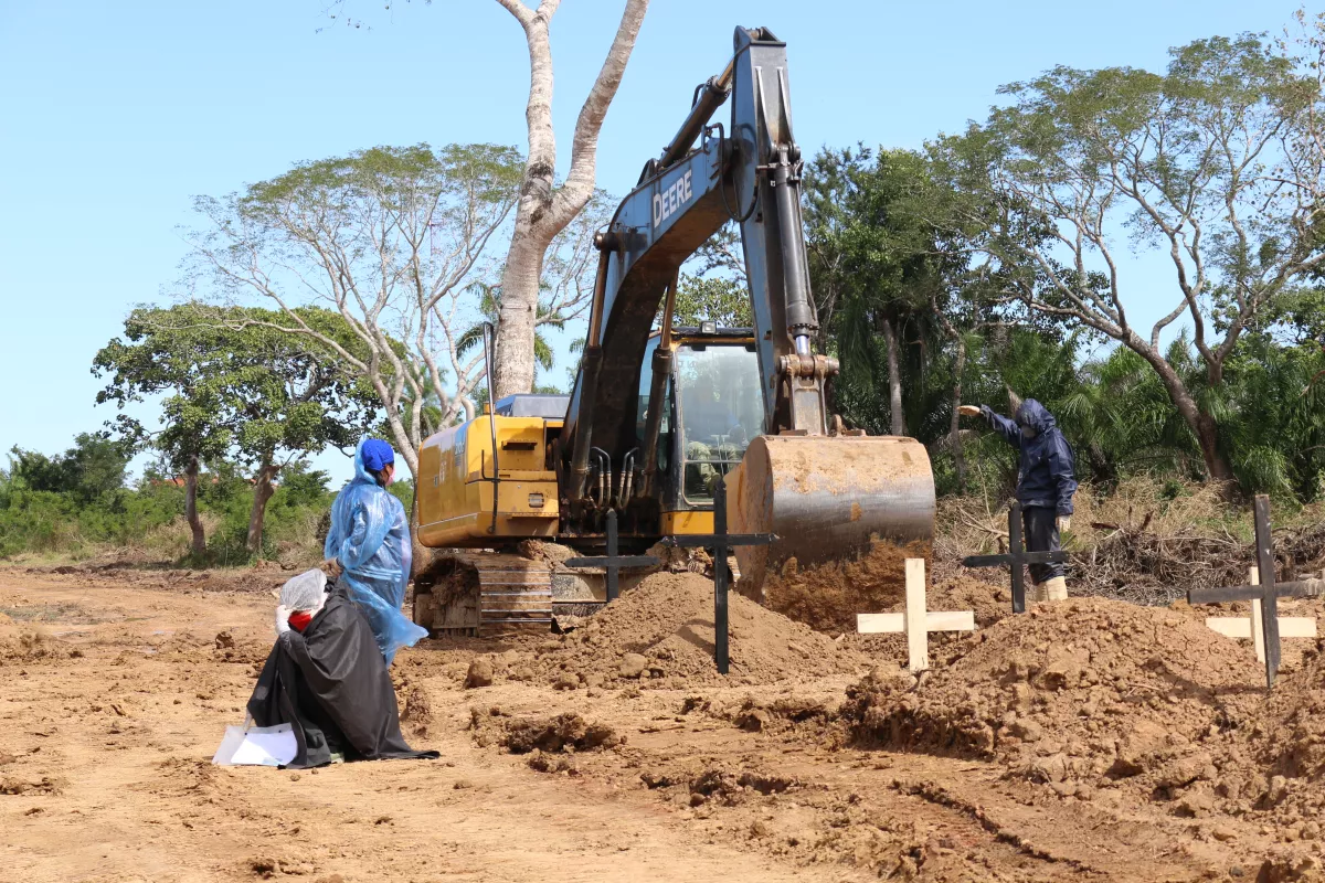Una mujer llora mientras espera que el tractor termine de hacer la fosa para enterrar a su familiar en un cementerio improvisado para víctimas de COVID-19. Crédito: Ricardo Gutiérrez
