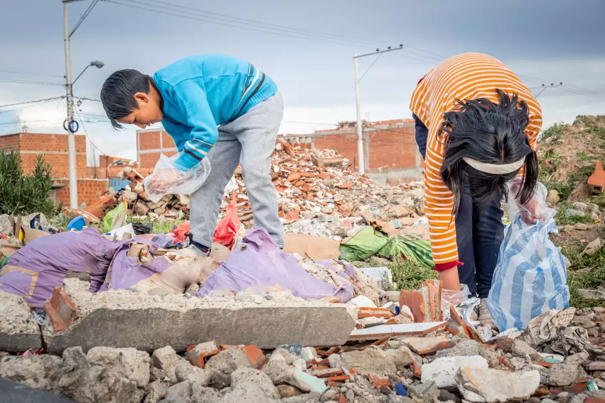 two latin kids recycling and cleaning up garbage in their city in latin america, bolivia - garbage recycling concept