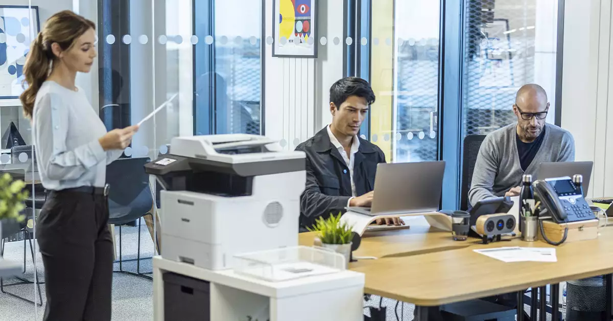 personas en una oficina con una impresora Brother