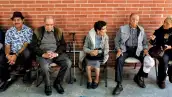 Varias personas de la tercera edad sentadas en sillas, algunas de ellas con bastón. 