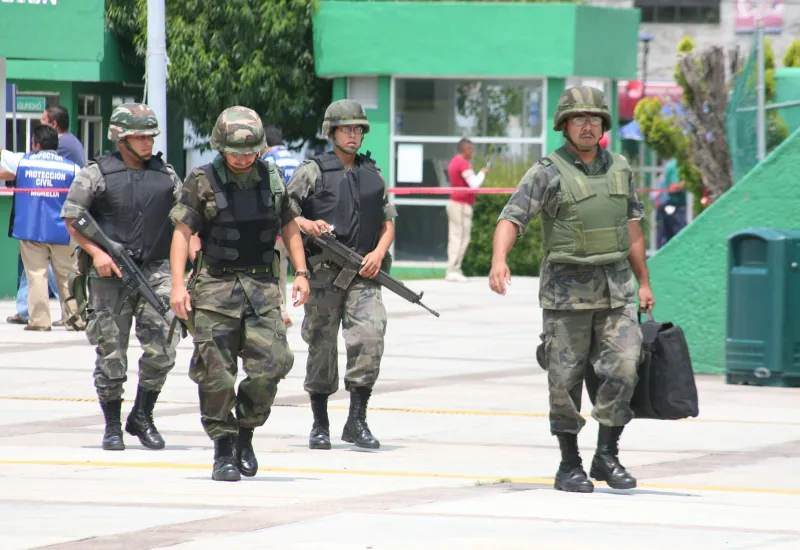 Cuatro elementos de las Fuerzas Armadas caminan con armas tras amenaza de bomba en Morelia durante las fiestas patrias de 2008. 