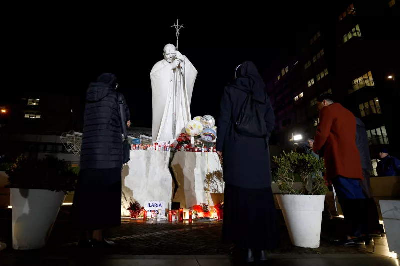 La gente reza fuera del Hospital Gemelli, donde el Papa Francisco es admitido para recibir tratamiento, en Roma, Italia, 23 de febrero de 2025.