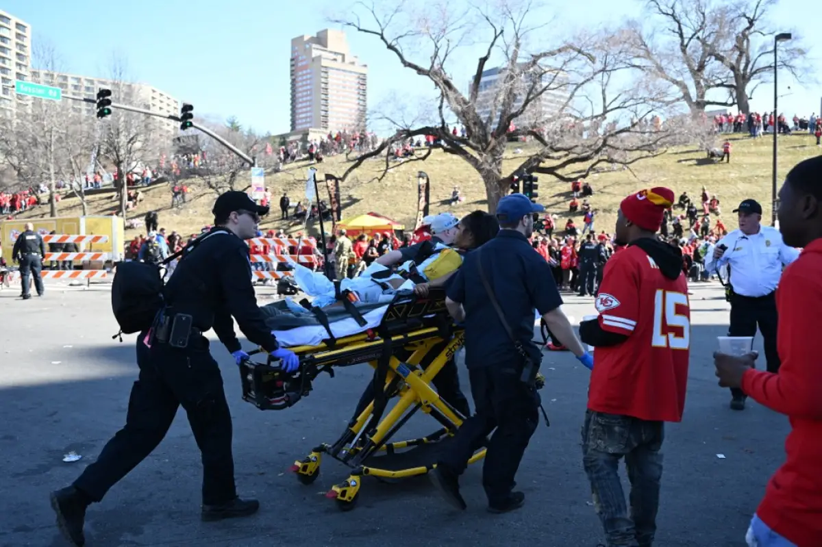 Una persona lesionada es ayudada por los socorristas cerca del desfile de la victoria del Super Bowl LVIII de los Kansas City Chiefs el 14 de febrero de 2024, en Kansas City, Missouri. Según se informa, se dispararon disparos durante el desfile, según la policía.