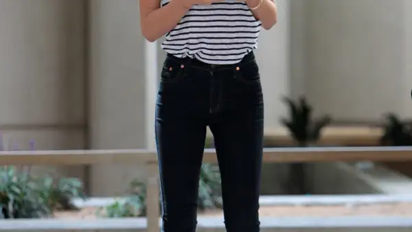 Para viajar comoda Miranda Kerr opta por uno jeans combinados con una t-shirt con motivos de rayas y unos flats rojos.