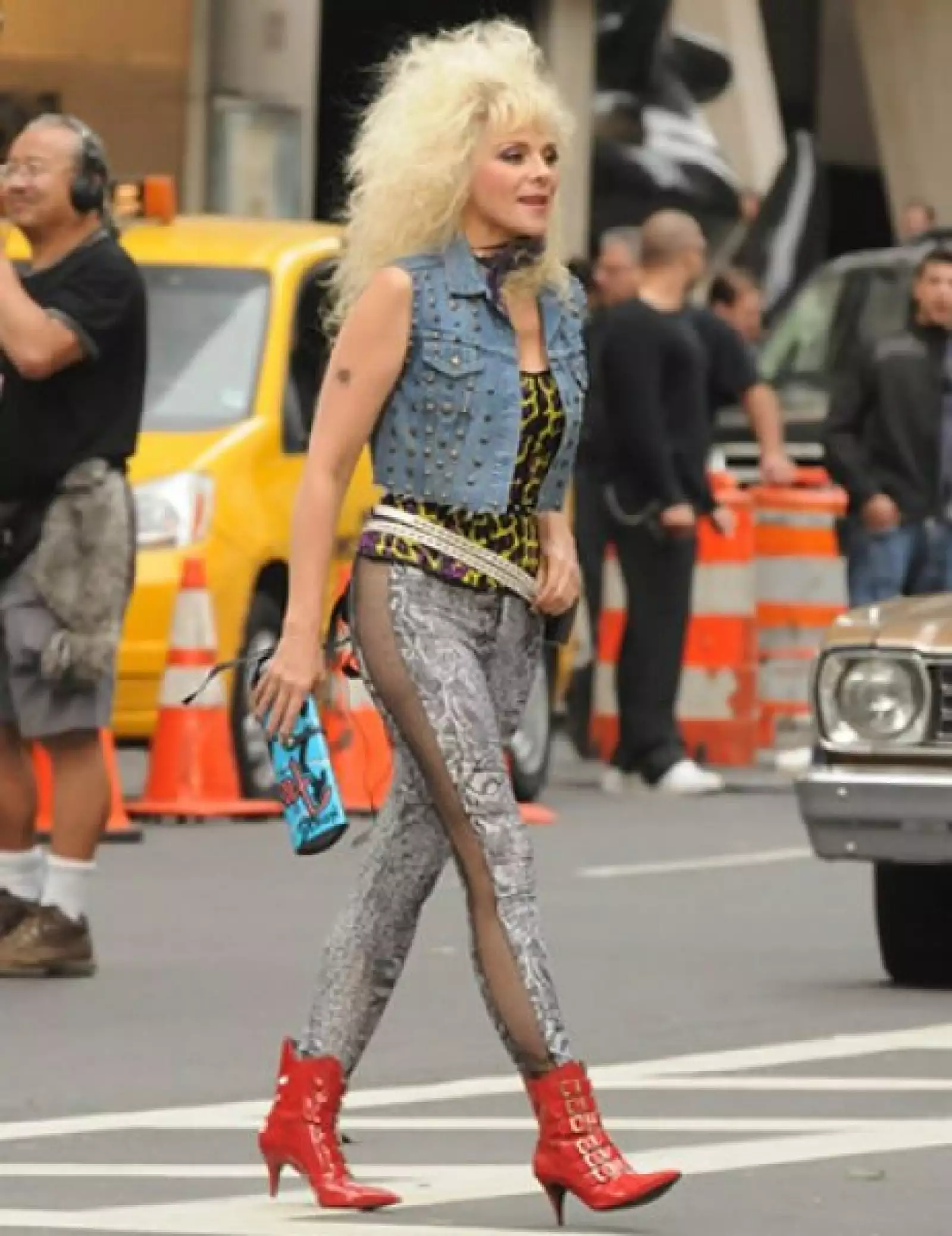 No se podía esperar menos de samantha: afro platinado, chaleco de mezclilla con estoperoles, skinny jeans abiertos a los lados y botas de PVC rojas son el look excéntrico que encaja con su personalidad.