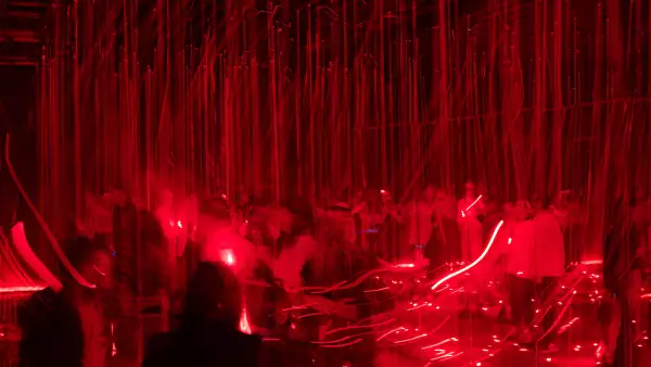 Imagen del espectáculo de láseres rojos en la obscuridad.