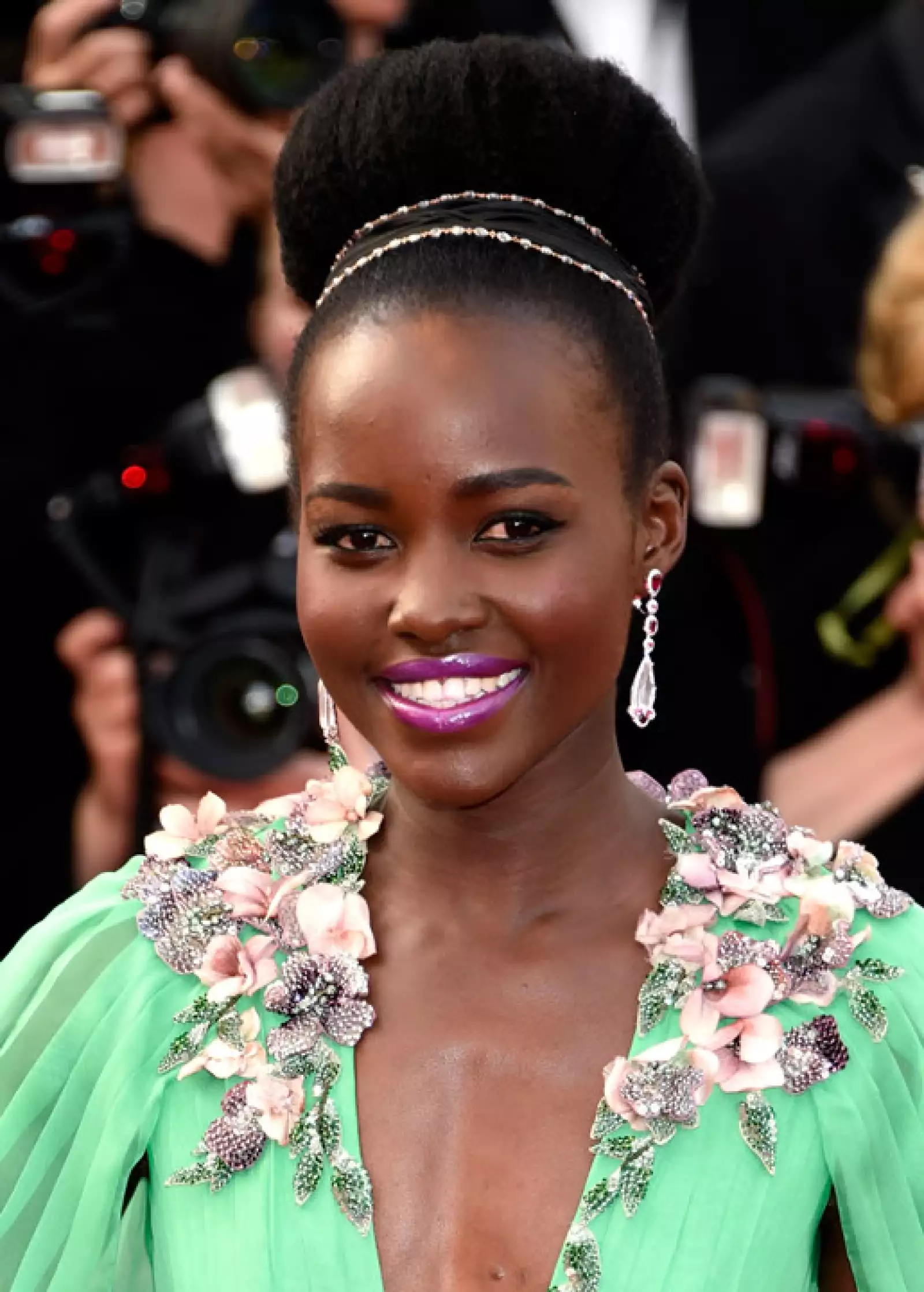 Para la premiere de La Tete Haute, Luptia Nyongo llevó un ballerina bun extra grande y extra glamouroso. Los labios morados hicieron que el vestido verde luciera aún más espectacular.