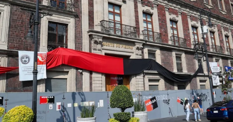 Sucursal de la Ciudad de México de Nacional Monte de Piedad cerrada y bardeada, con banderas rojas y negras colocadas por los trabajadores que se mantienen en huelga desde el 1 de septiembre de 2025.