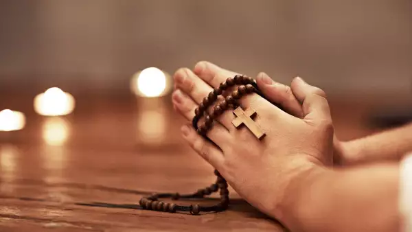 Consejos del papa Francisco para hacer una buena confesión. (Manos de una persona rezando con un rosario).