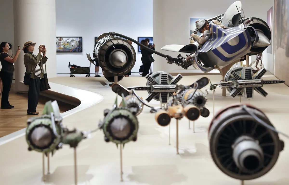 Unos visitantes toman fotografías en la exposición "Star Wars in Motion" del nuevo Lucas Museum of Narrative Art.