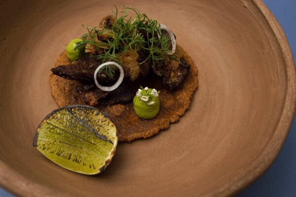 Taco de cachete con cilantro, aguacate y cebolla