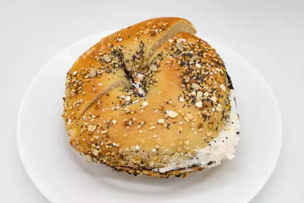 Everything Bagel with Lox Cream Cheese Spread on a White Plate with a White Background