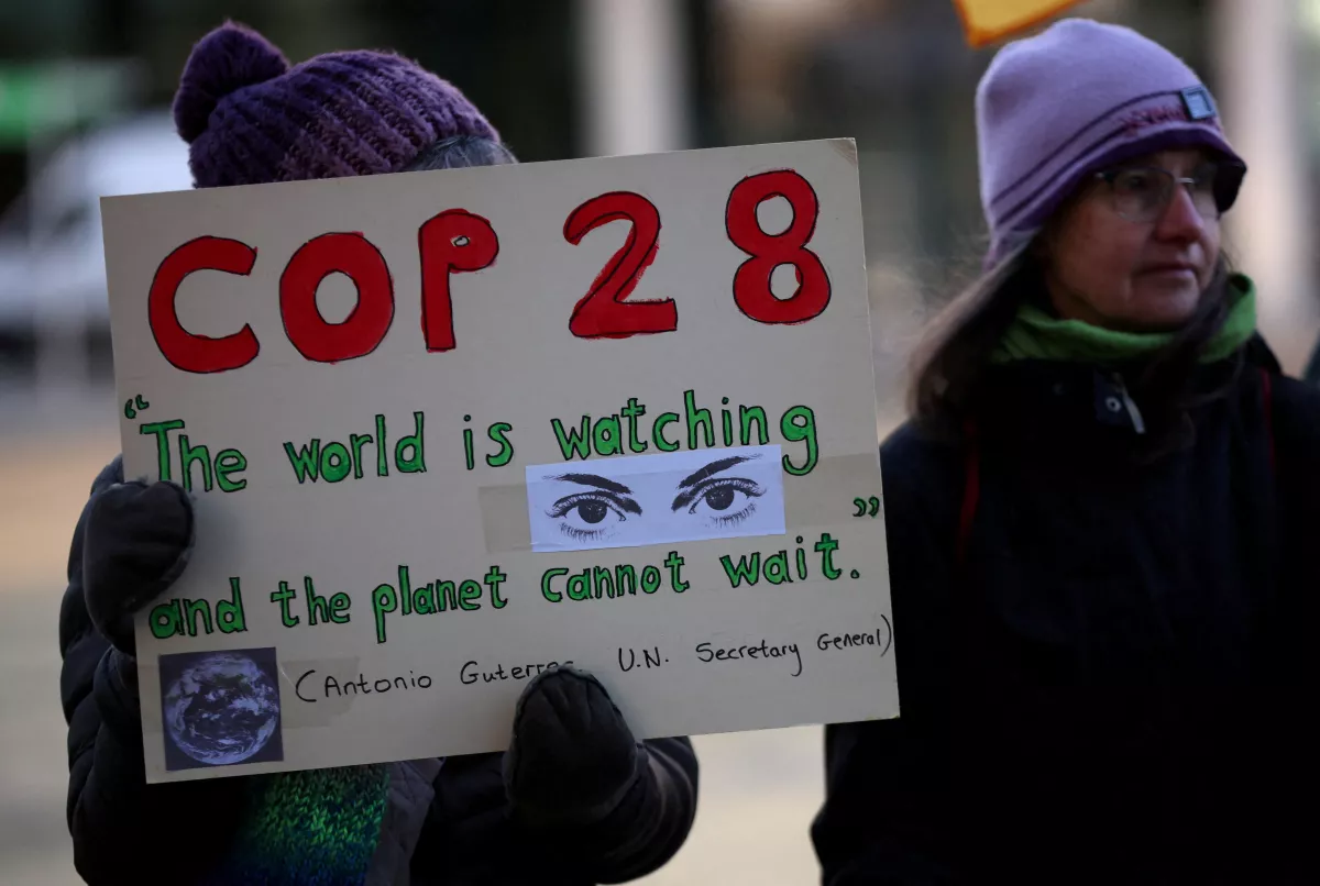 Un activista climático sostiene un cartel durante una vigilia para conmemorar el día de apertura de la cumbre de la COP28 fuera de las oficinas de la BBC en Salford, Gran Bretaña, el 30 de noviembre de 2023.