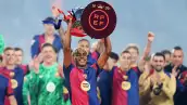Foto de Lamine Yamal cargando el trofeo de LaLiga luego de que el Barcelona venció al Villarreal el 18 de mayo de 2025.