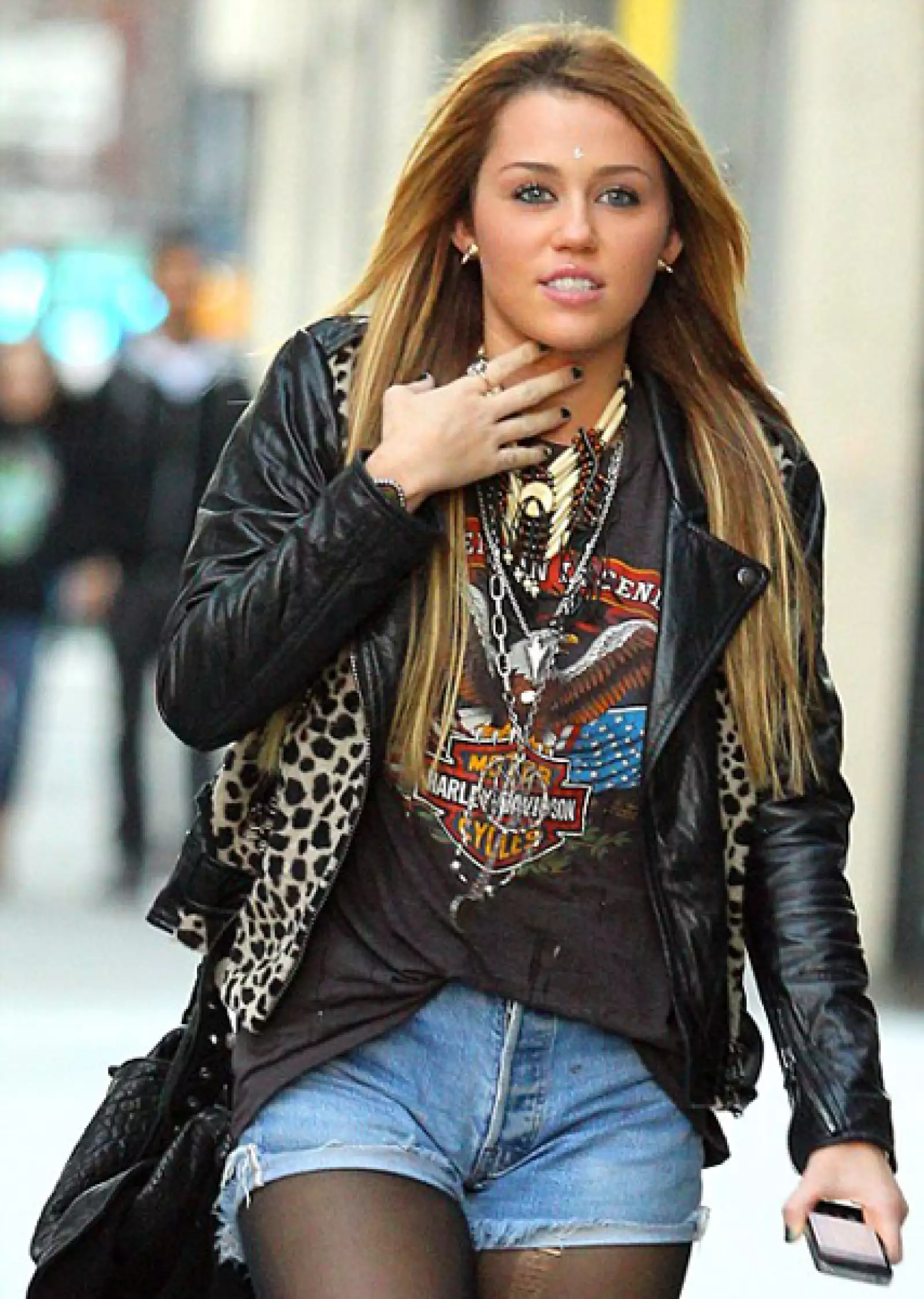 Miley Cyrus integra varios elementos rockeros en su guardarropa como lo son los shorts y las medias, una chaqueta de cuero y varias cadenas y collares.