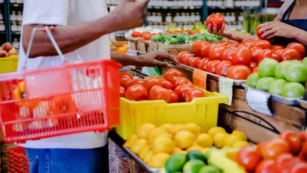 Unrecognizeable customer talks with the supermarket employee