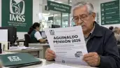 Adulto mayor revisa en una oficina del IMSS un documento con el encabezado “Aguinaldo pensión 2026”.