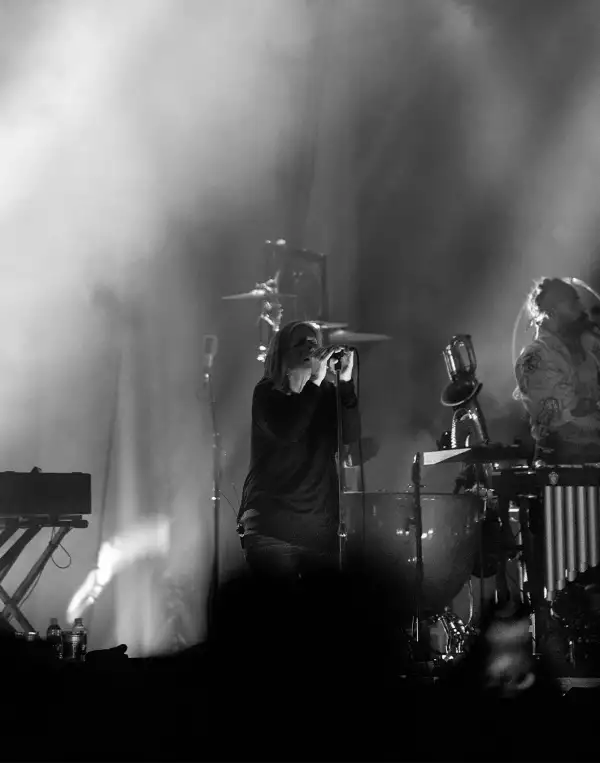 Foto en blanco y negro de Beth Gibbons cantando en el escenario.