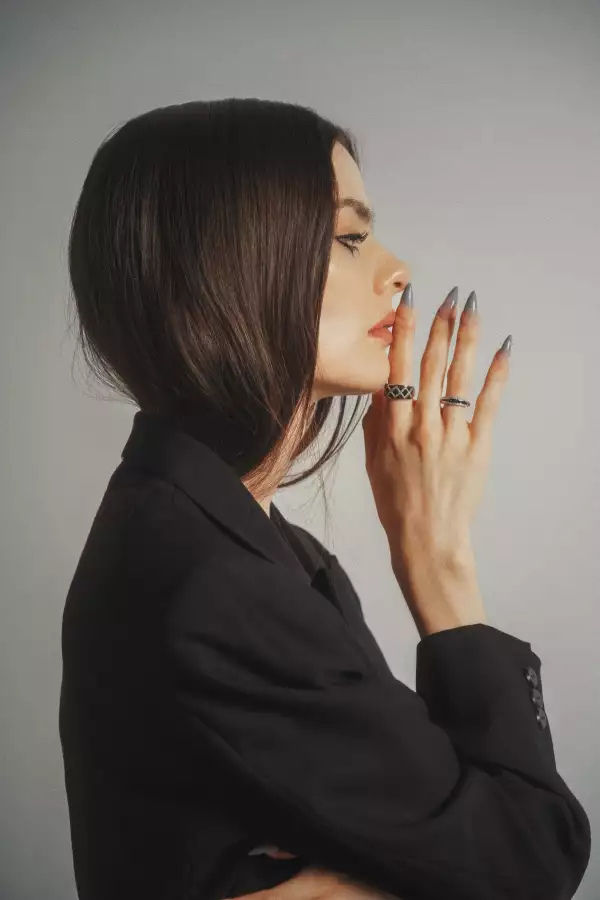 Mujer de perfil portando anillos de la colecciónde Bizzarro de oro blanco con diamante negro.