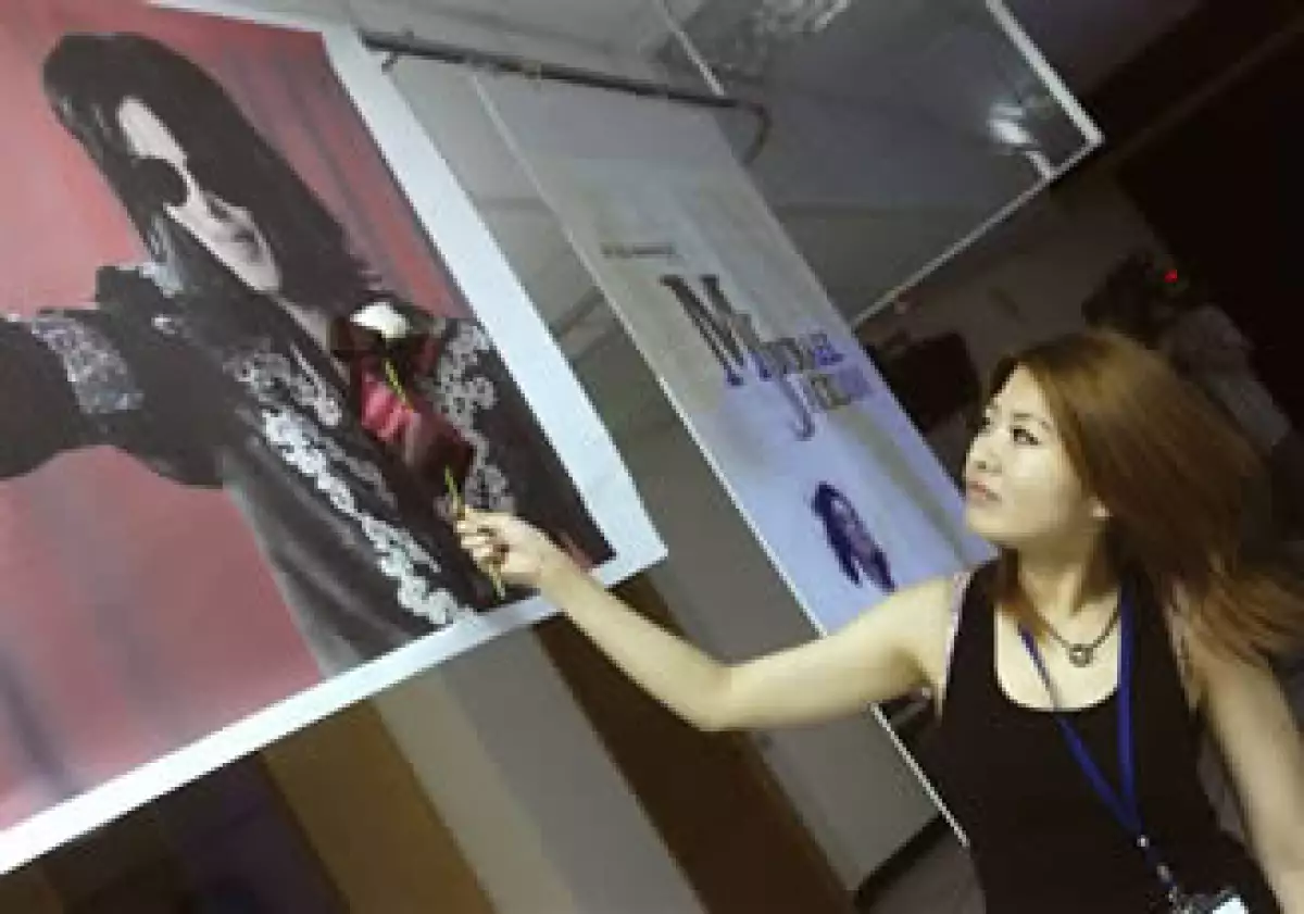 Una taiwanesa seguidora de Michael Jackson acerca una rosa blanca a un retrato del astro (AP).