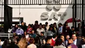 En la imagen se aprecia a trabajadores del SAT haciendo fila para entrar a las oficinas. 