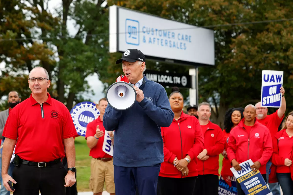El presidente de los Estados Unidos, Joe Biden, habla junto a Shawn Fain, presidente de United Auto Workers (UAW), mientras se une a los miembros en huelga de United Auto Workers (UAW) en la línea de piquete fuera del Centro de Distribución Willow Run de GM, en Belleville, Condado de Wayne, Michigan, Estados Unidos, el 26 de septiembre de 2023.