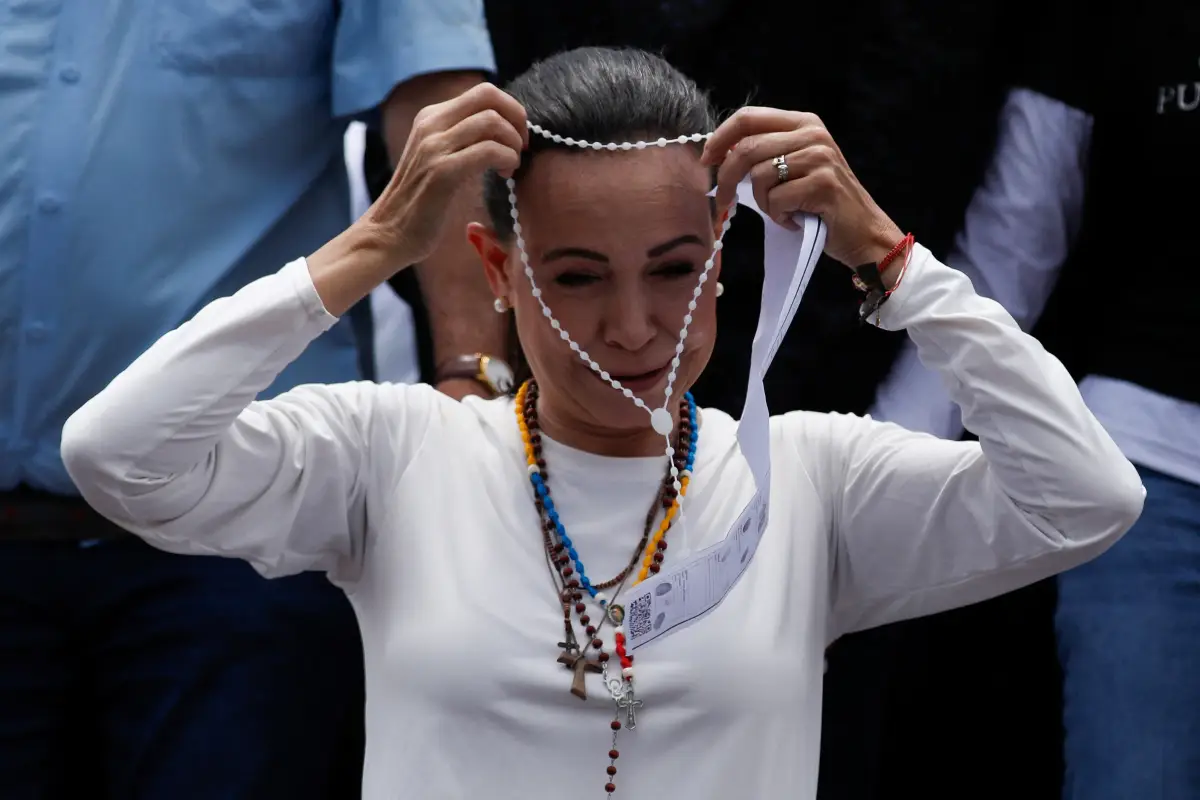 La líder opositora venezolana, María Corina Machado, sostiene un rosario durante una marcha en medio de las disputadas elecciones presidenciales, en Caracas, Venezuela, el 17 de agosto de 2024.