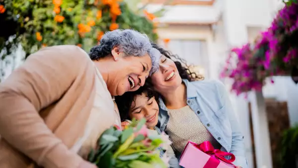 Family embraced and holding gifts outdoors