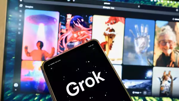 La aplicación Grok en un teléfono móvil frente a una pantalla con imágenes generadas por IA