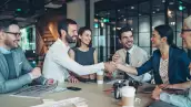 En algunos países la semana laboral de cuatro días ya es una realidad. (Grupo de personas felices en una oficina).