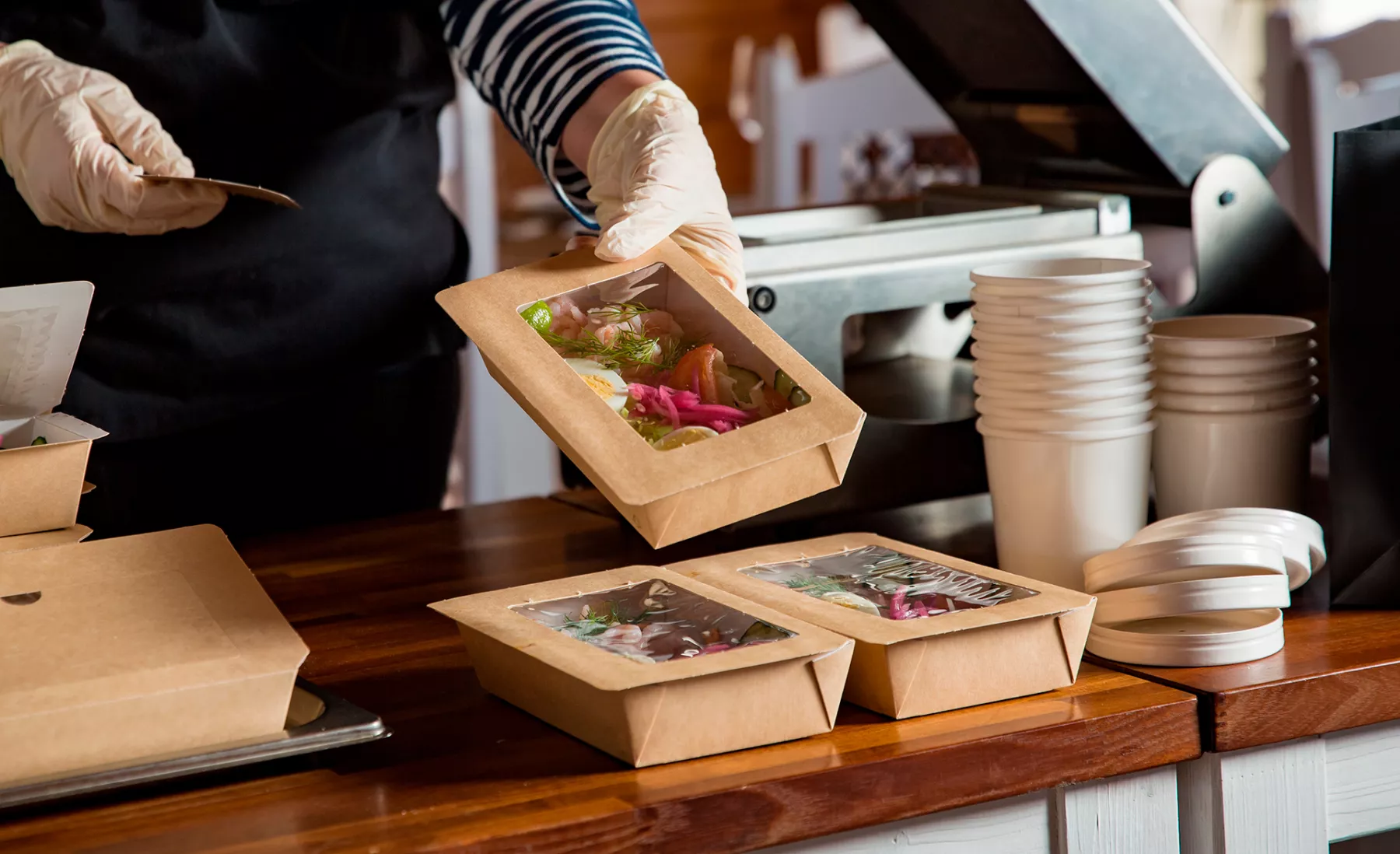 Un cocinero de un restaurante empaca varios pedidos para entregar por Rappi, el aliado de restaurantes.