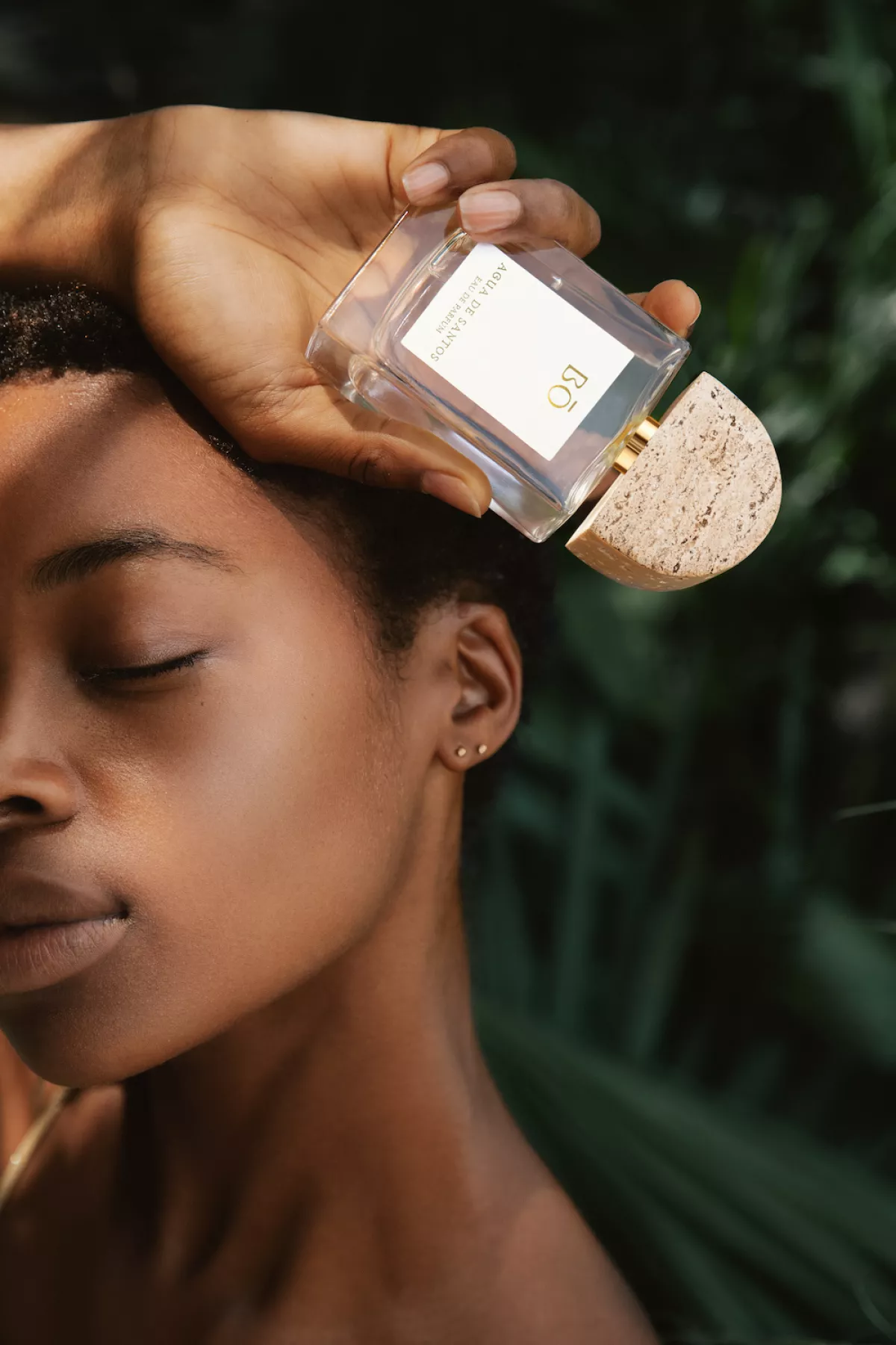 Mujer sosteniendo un perfume de House of Bō