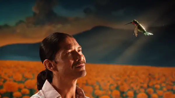 Javier observa un colibrí frente a un campo de cempasúchil en la campaña de Día de Muertos 2026 de Victoria.