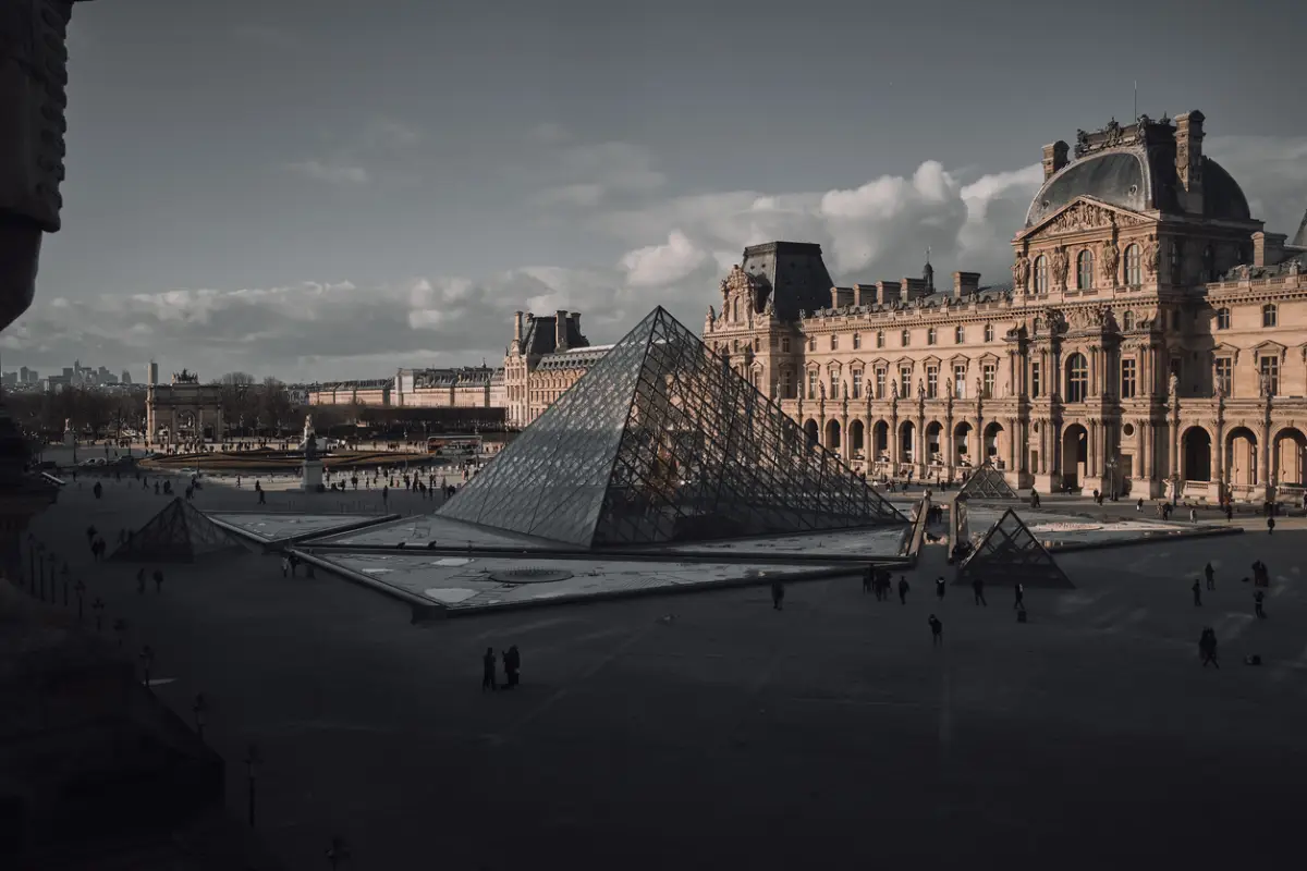 High angle shot of the Louvre in Paris, France with people walking around it