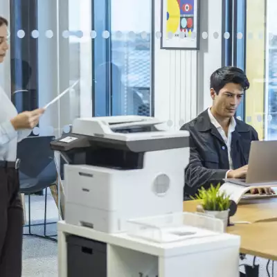 personas en una oficina con una impresora Brother