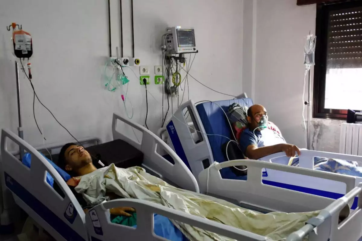 Esta foto de cortesía publicada por la Agencia Oficial de Noticias Árabe Siria (SANA) el 5 de octubre de 2023, muestra a personas heridas en el ataque con aviones no tripulados dirigido a una academia militar siria que recibe tratamiento médico en un hospital de Homs controlado por el gobierno.
