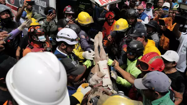 Los rescatistas llevan a una persona después de ser sacado vivo de los escombros de un edificio derrumbado en Caraballeda, estado de La Guaira, Venezuela, el 28 de junio de 2026, después de terremotos.