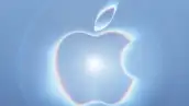 Logo de Apple iluminado por una luz blanca en un fondo color azul.