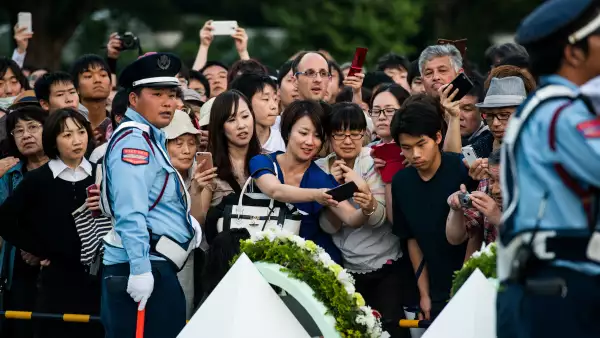 En su discurso, Obama evitó cualquier expresión de remordimiento o de disculpas por los bombardeos. Aquí, los japoneses tratan de tomar una foto del arreglo colocado por el presidente de EU.