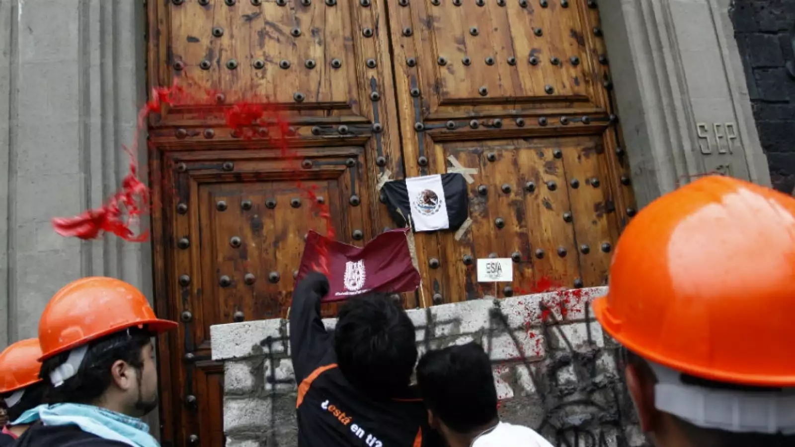 Estudiantes del IPN construyen muro con tabiques y cemento frente a la puerta principal de la SEP 