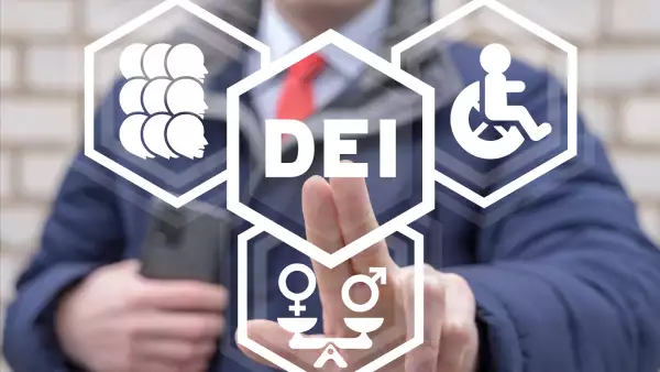 Al fondo, una persona muestra en primer plano el concepto de diversidad, equidad e inclusión (DEI)