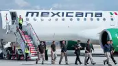 Elementos de la Marina y miembros de la tripulación de Mexicana de Aviación descienden de una aeronave. 