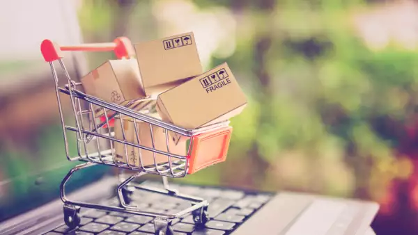 Online shopping and delivery service concept. Paper cartons in a shopping cart on a laptop keyboard, this image implies online shopping that customer order things from retailer sites via the internet.