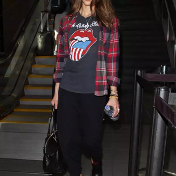 Para viajar cómoda Jessica Alaba combina una playera de los Rolling Stones con una camisa de franela a cuadros.